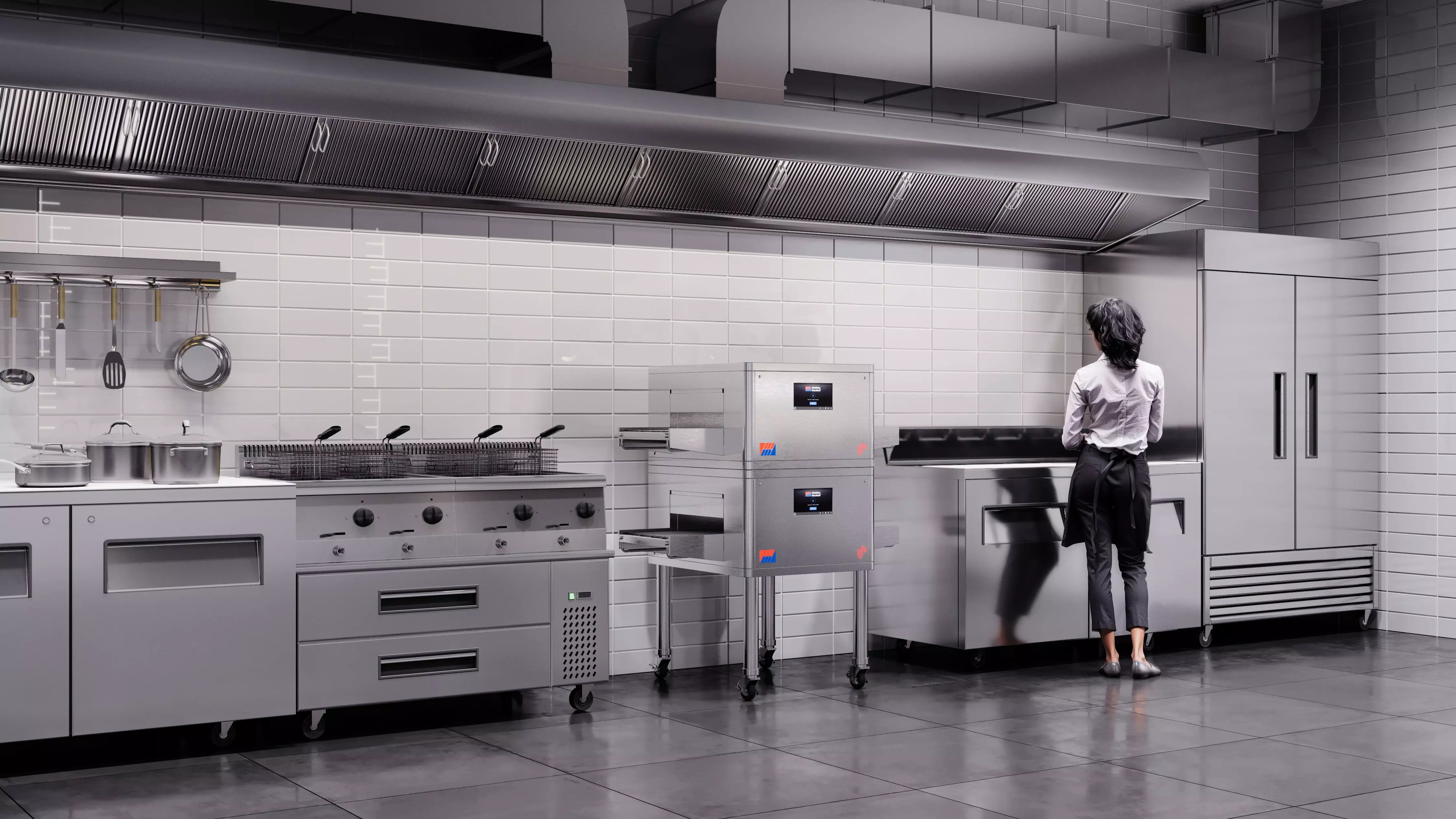 A photo of a kitchen that includes a commercial conveyor oven with a self-cleaning button for ease of maintenance
